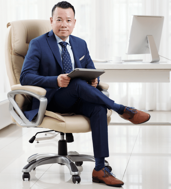Full-shot-successful-asian-business-executive-sitting-cross-legged-his-luxury-boss-chair-light-spacious-office